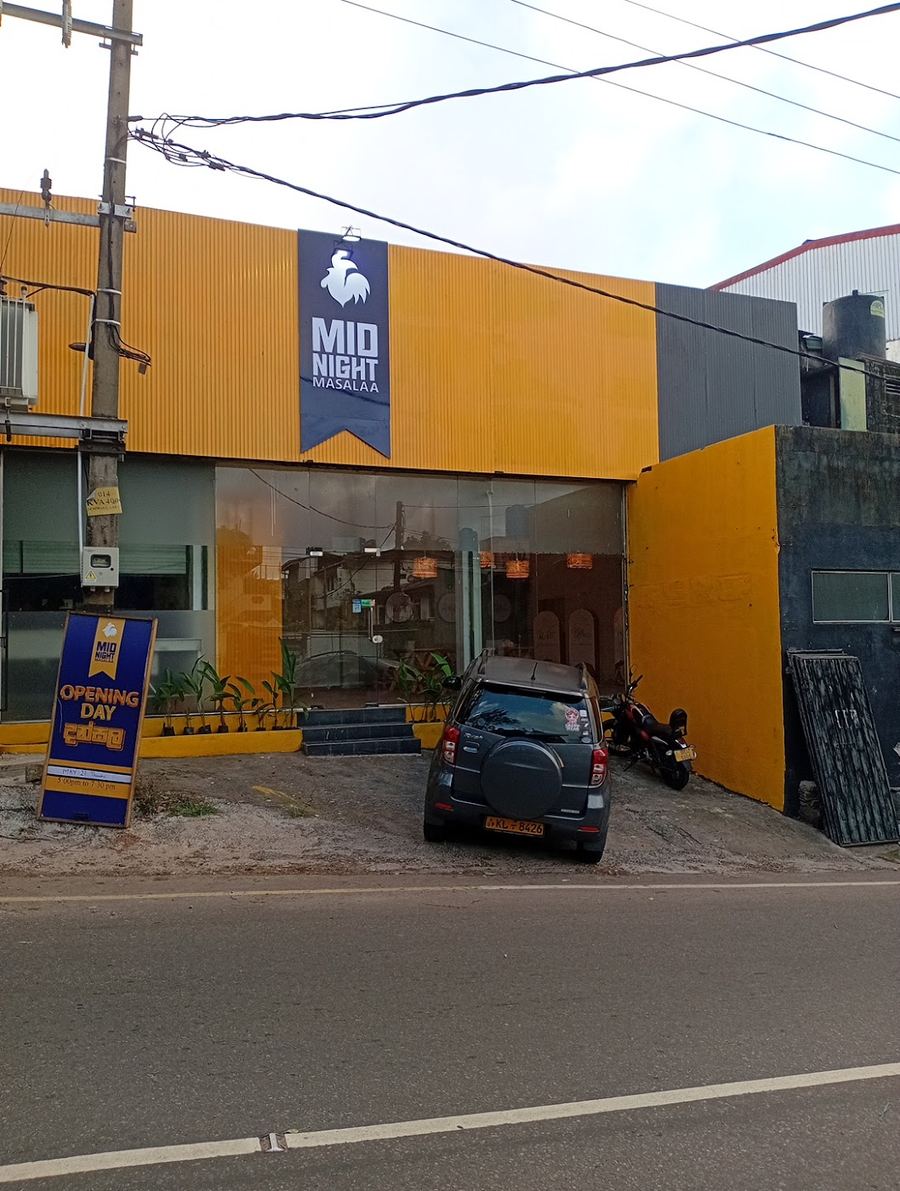 Midnight Masalaa Dehiwala — golden storefront with the navy rooster sign